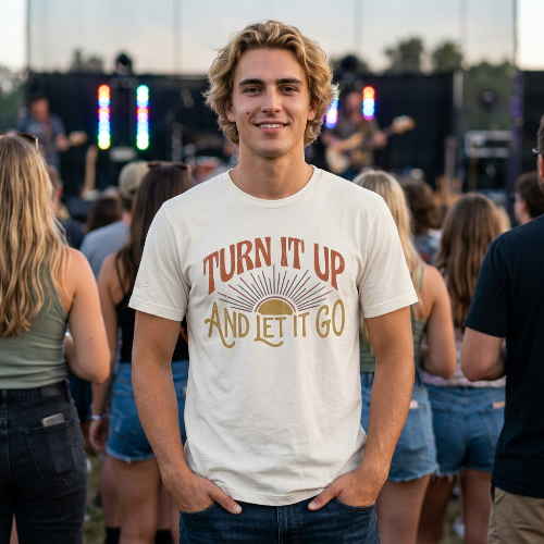 Man wearing a t-shirt with 'Turn It Up And Let It Go' at a concert.