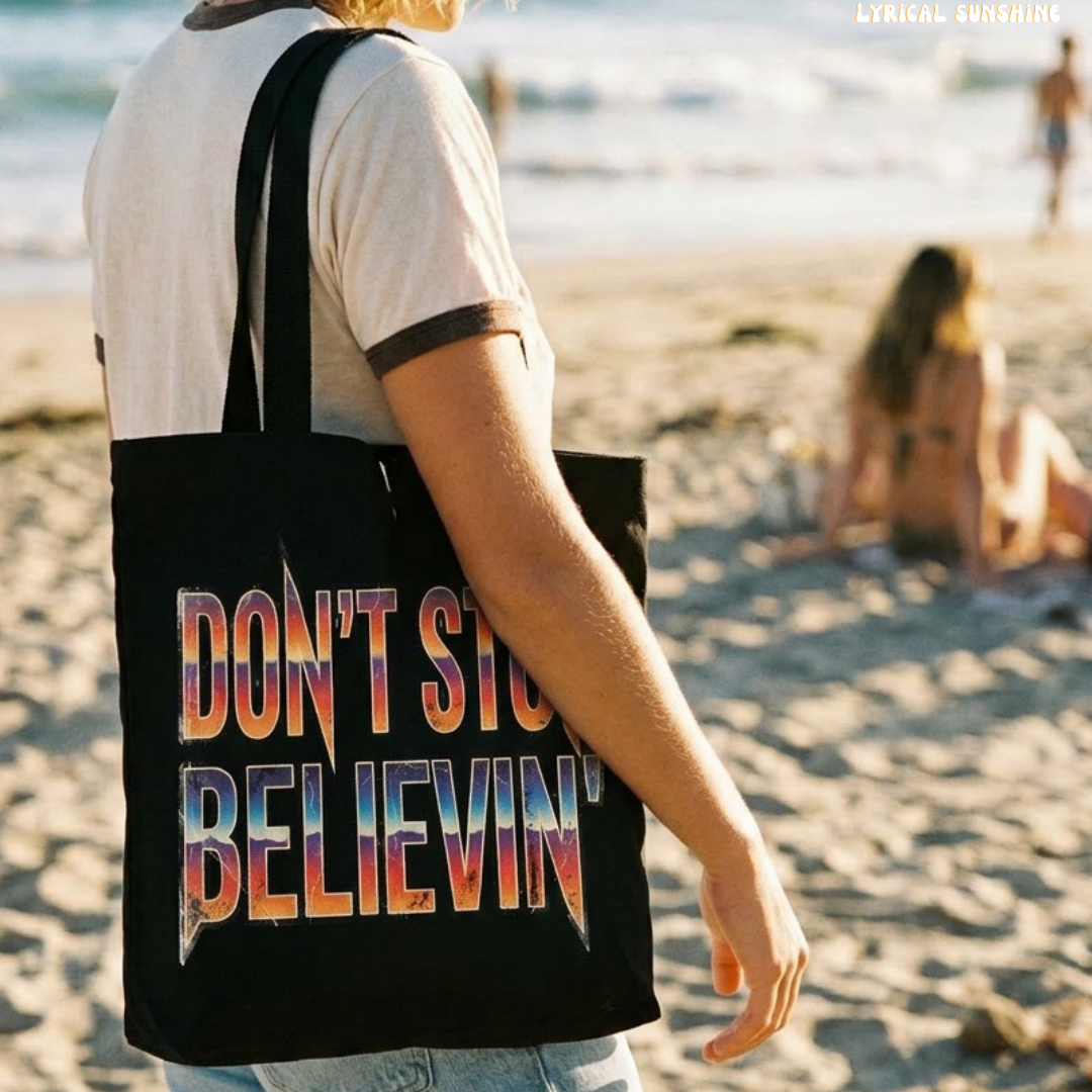 Person on a beach with a tote bag that says 'Don't Stop Believing'