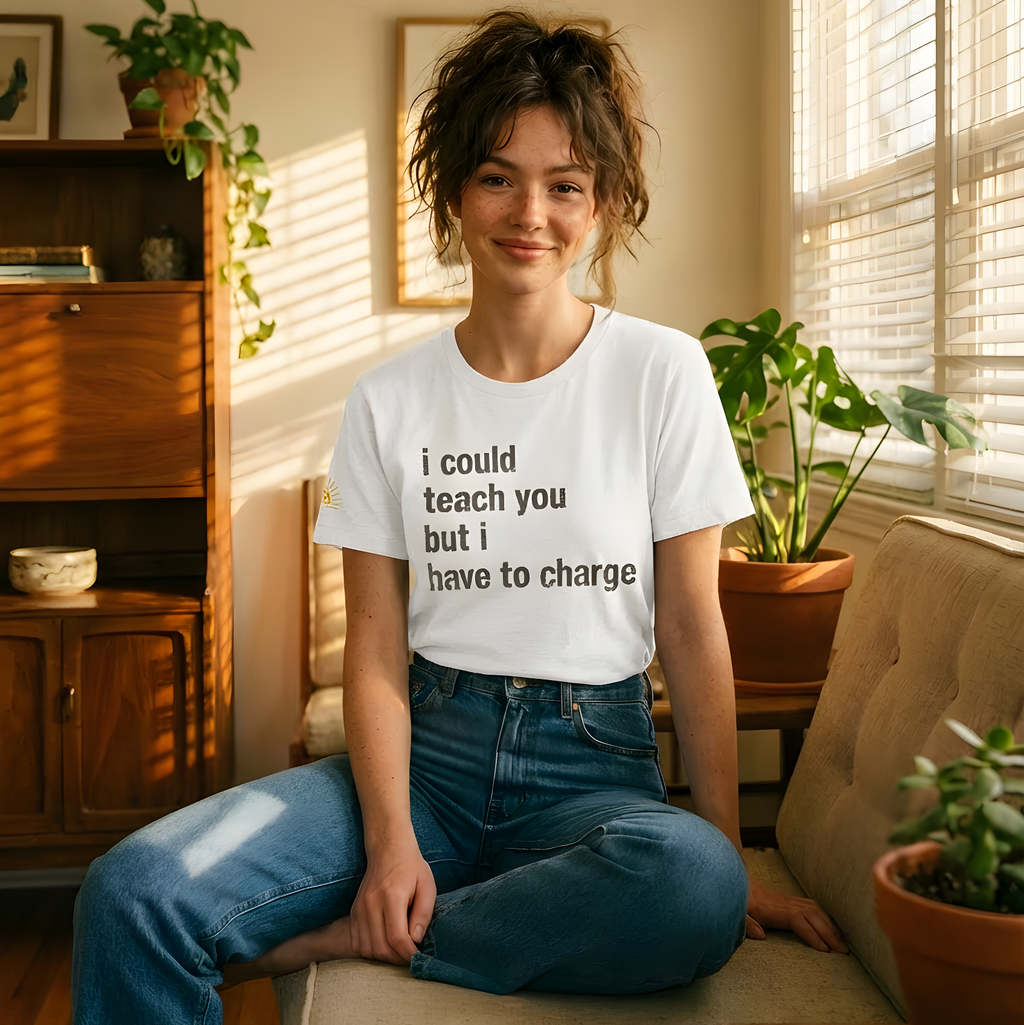 Woman sitting on a couch wearing a white t-shirt with text, surrounded by plants and sunlight.