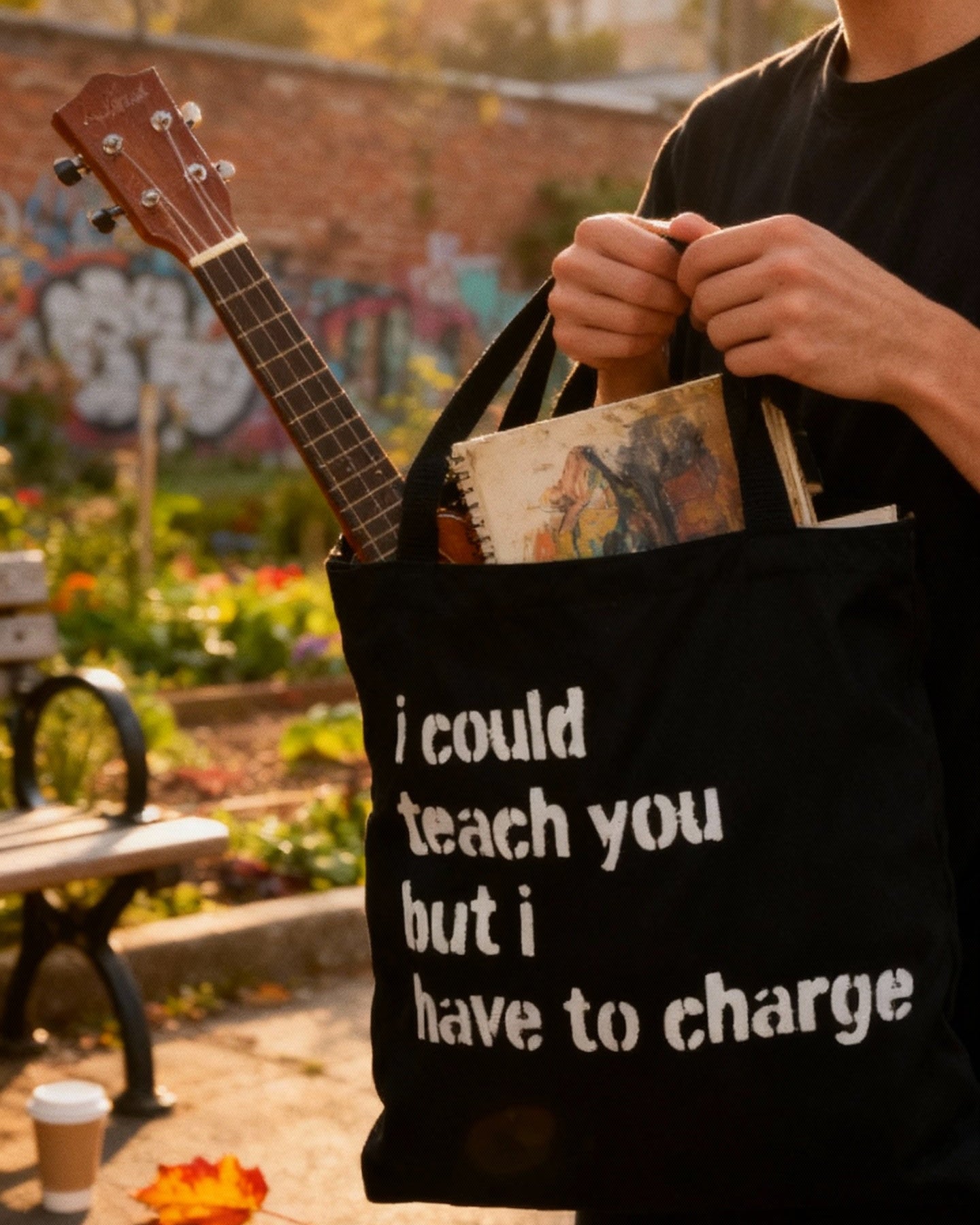 Person holding a black tote bag with text in an outdoor setting