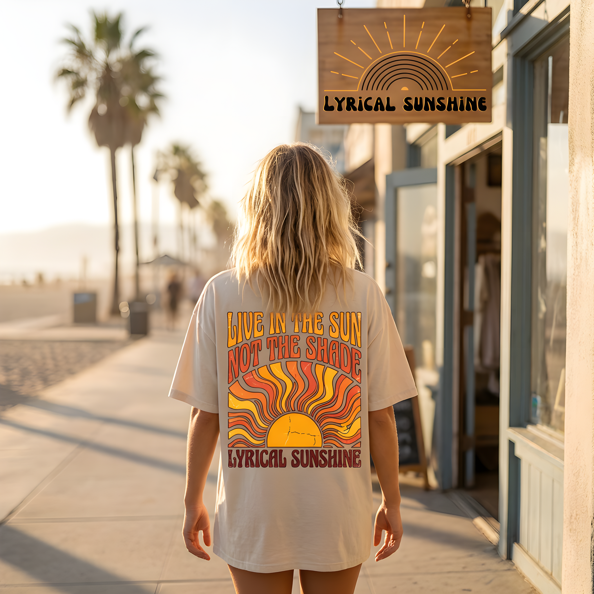 Person wearing a t-shirt with 'Lyrical Sunshine' design on a boardwalk with palm trees.