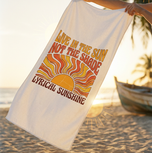 Person holding a towel with 'Lyrical Sunshine' branding and text on a beach.