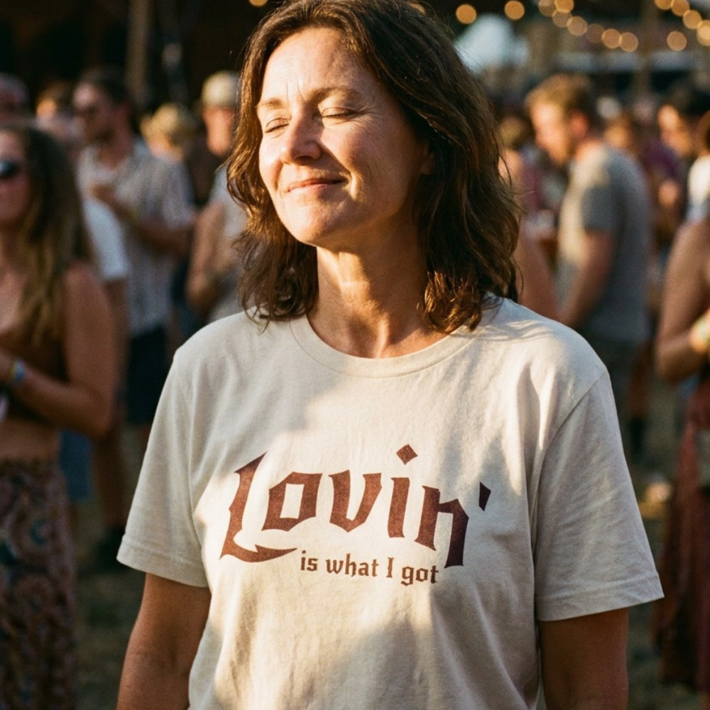Woman wearing a t-shirt with 'Lovin is what I got' at a festival.