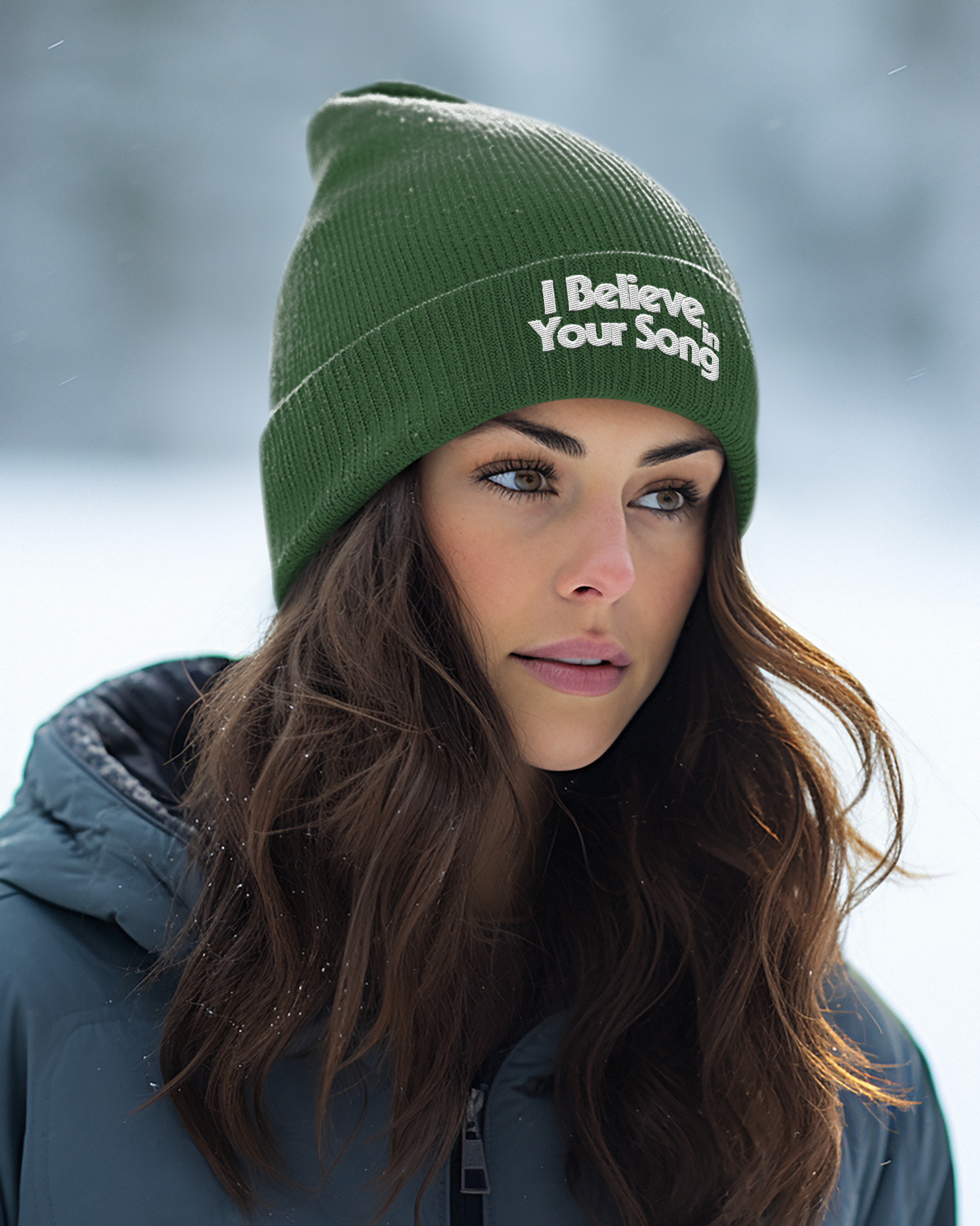 Woman wearing a green beanie with 'I Believe Your Song' text against a snowy background