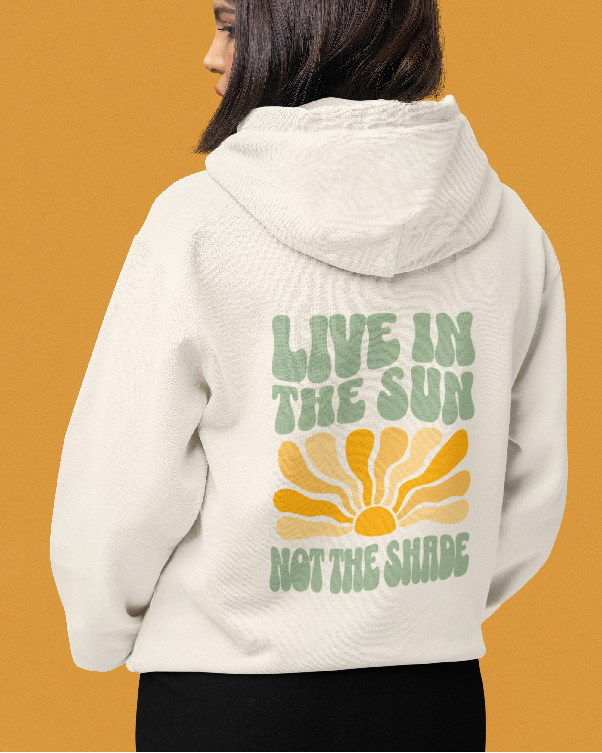 Person wearing a hoodie with 'Live in the Sun, Not the Shade' text on the back against an orange background
