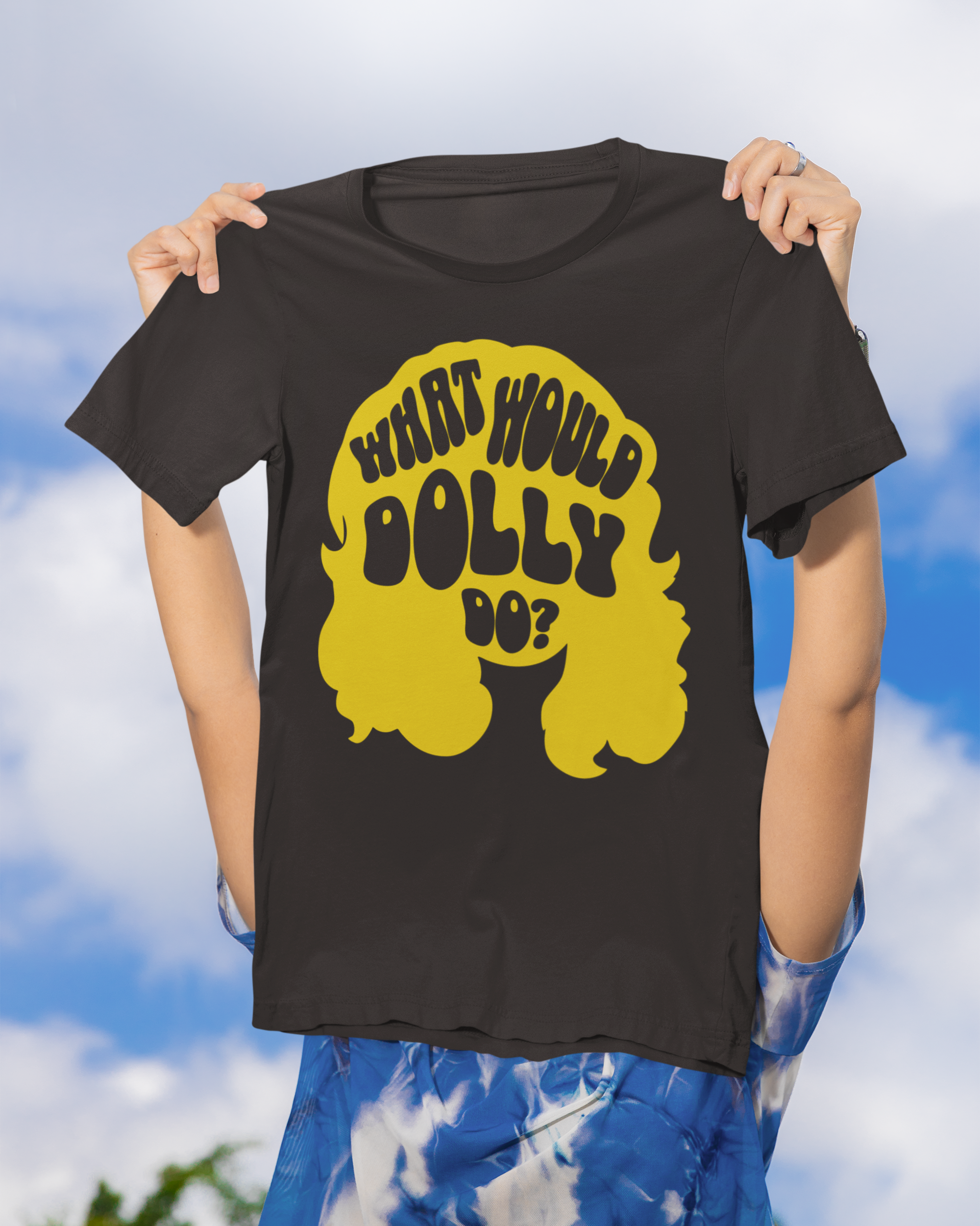 Person wearing a black t-shirt with yellow graphic and text against a blue sky background