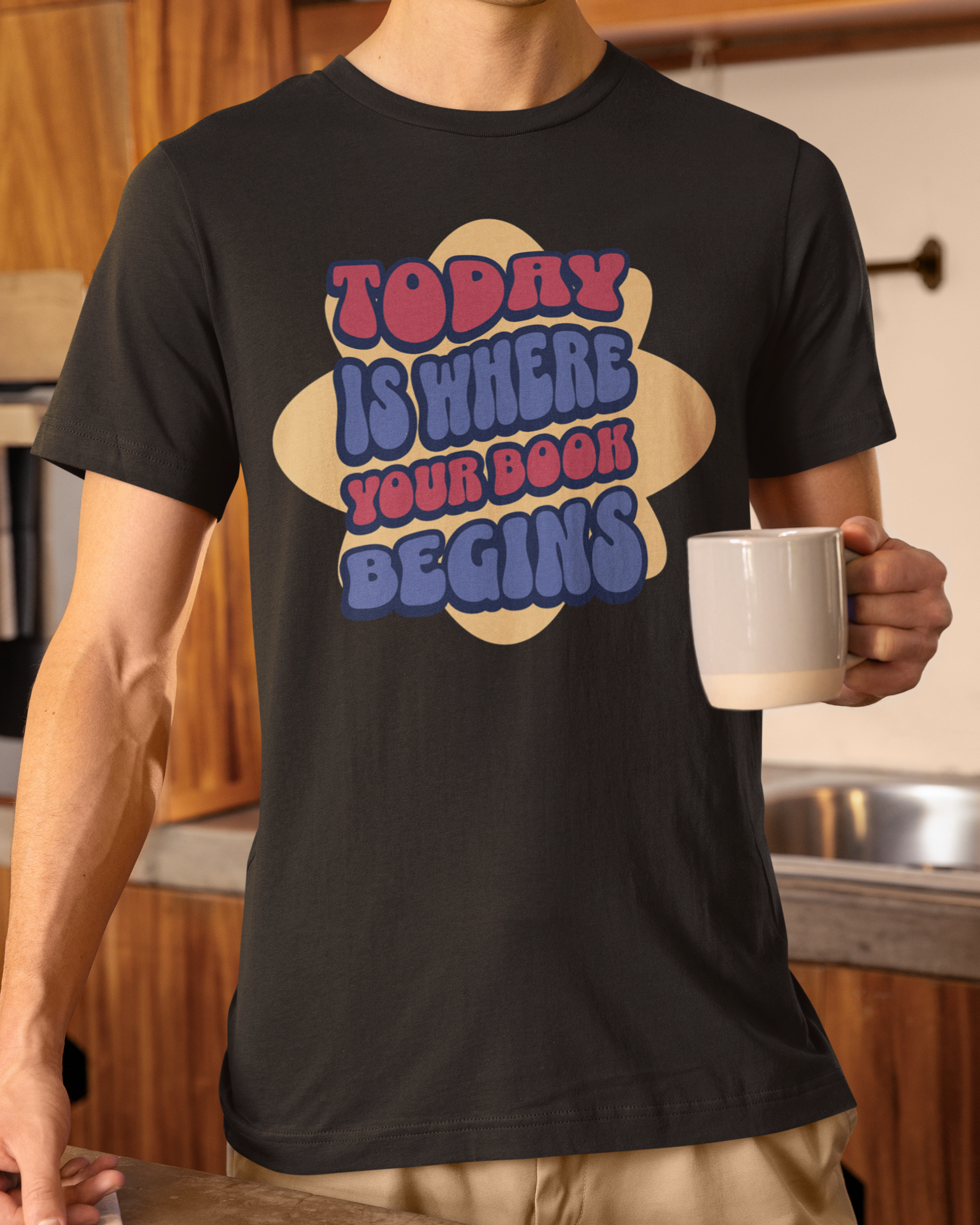 Person wearing a black t-shirt with colorful text in a kitchen