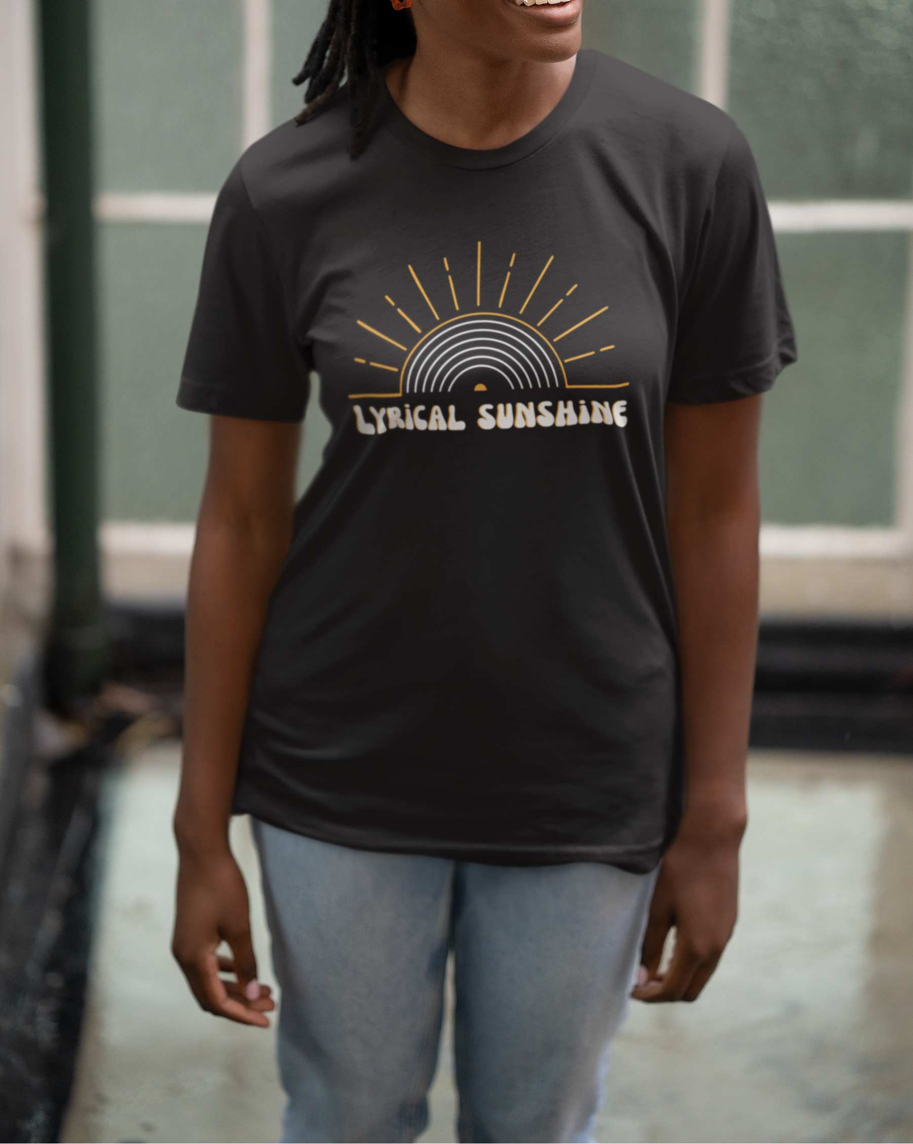 Person wearing a black t-shirt with 'Lyrical Sunshine' design in an indoor setting.