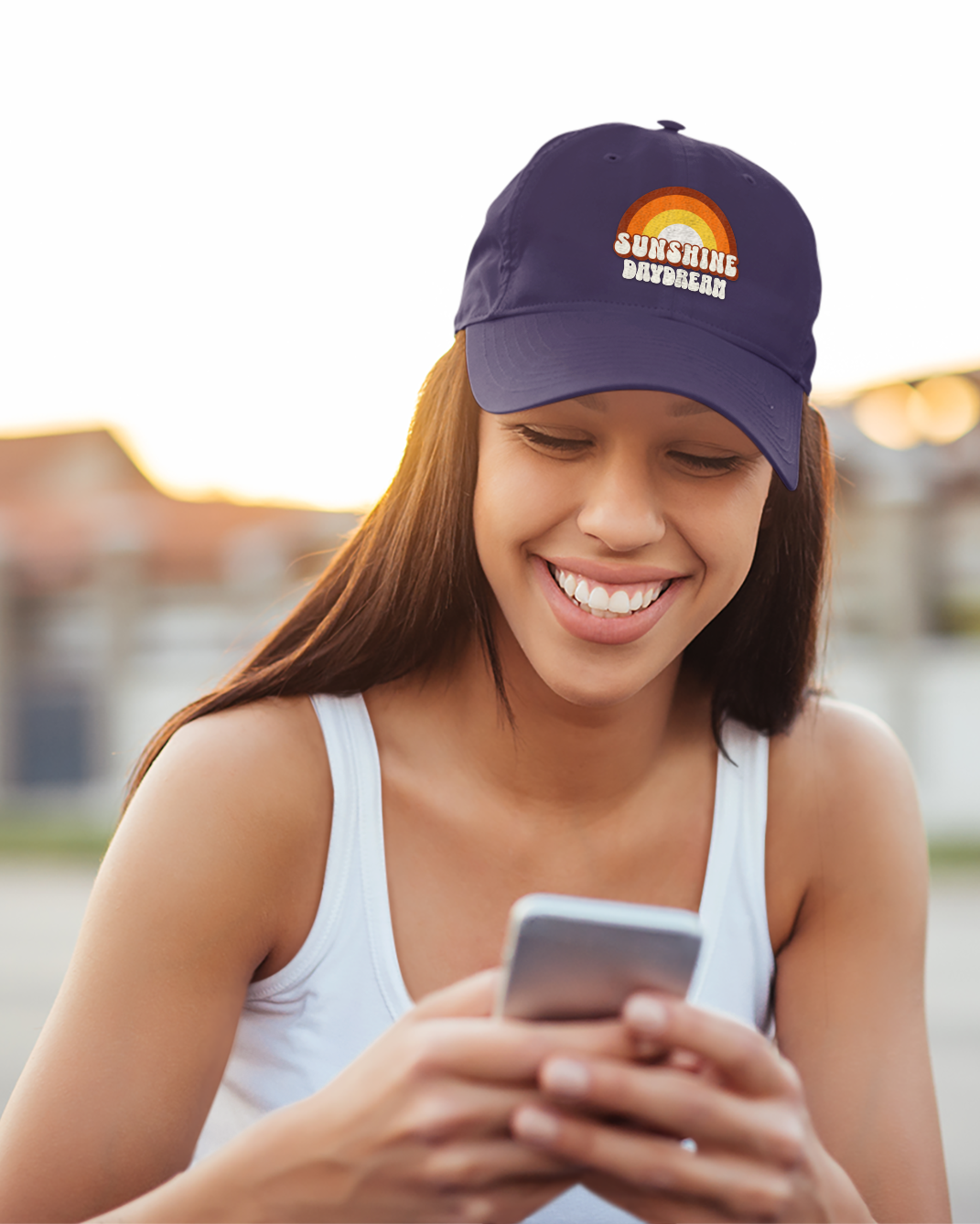 Woman wearing a cap and using a phone outdoors
