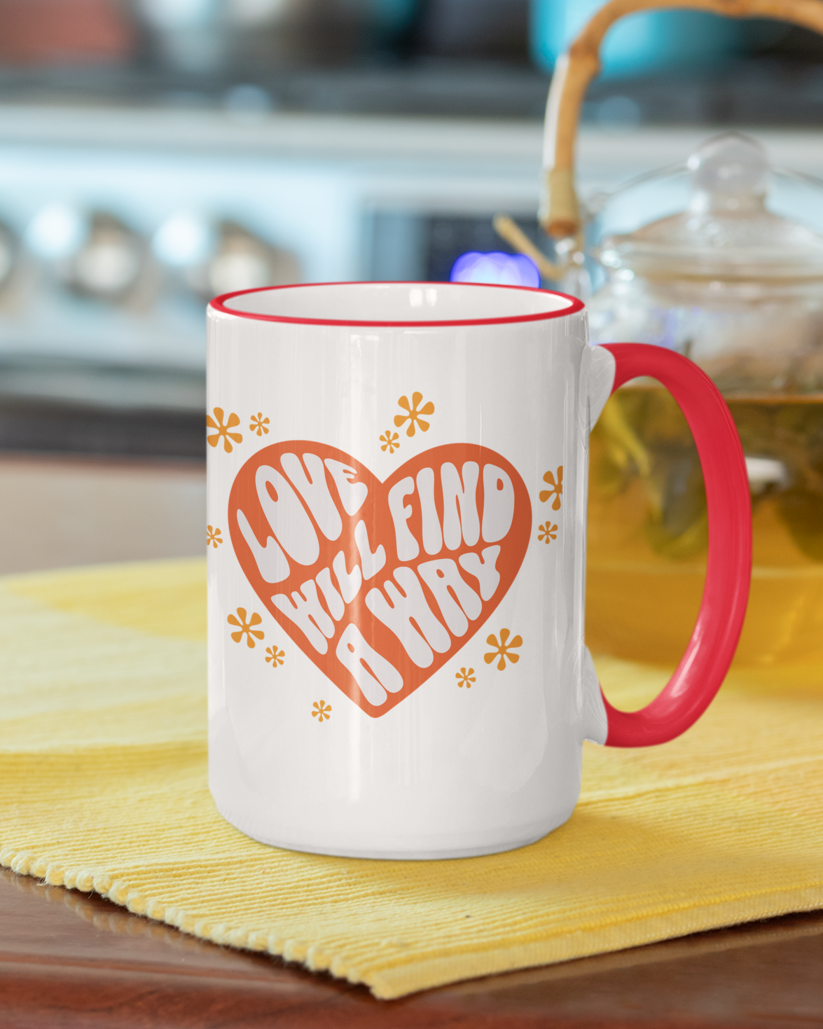 White mug with red handle and red heart design on a yellow mat in a kitchen setting