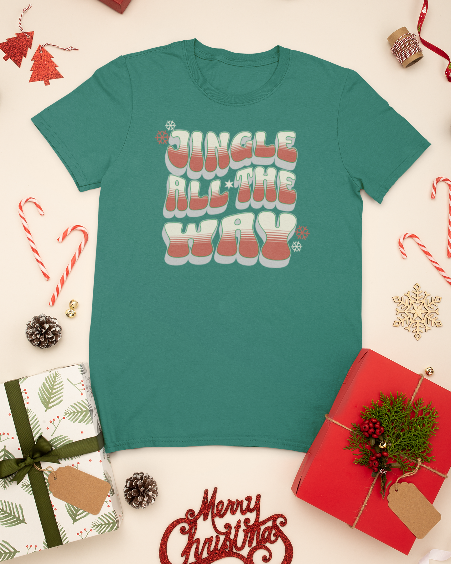 Teal t-shirt with 'Jingle All The Way' text on a Christmas-themed background with presents and decorations.
