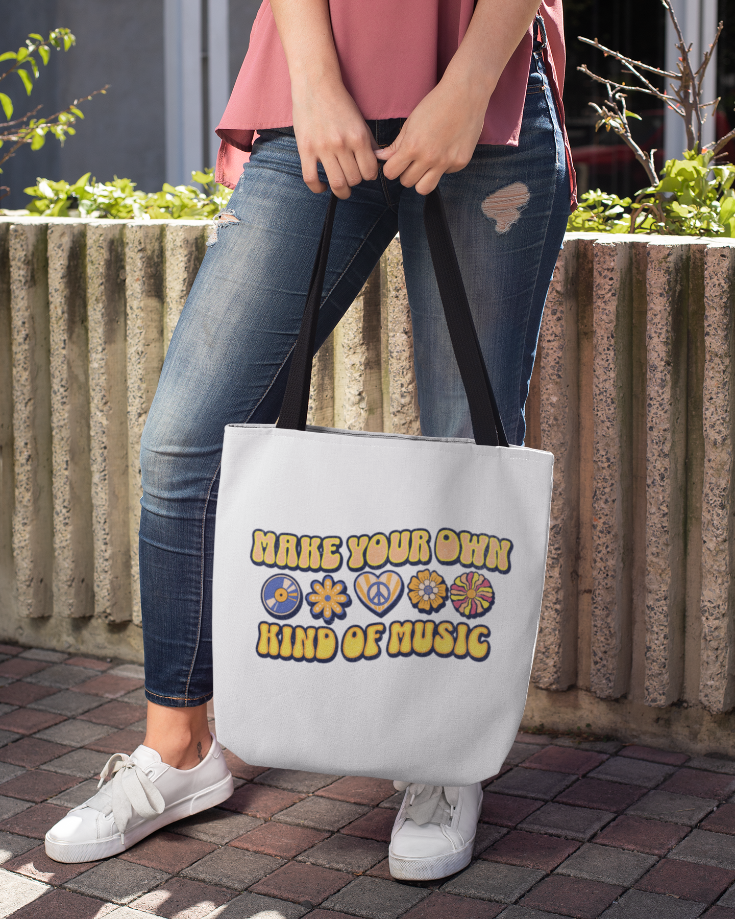Person holding a tote bag with 'Make Your Own Kind of Music' text and symbols.