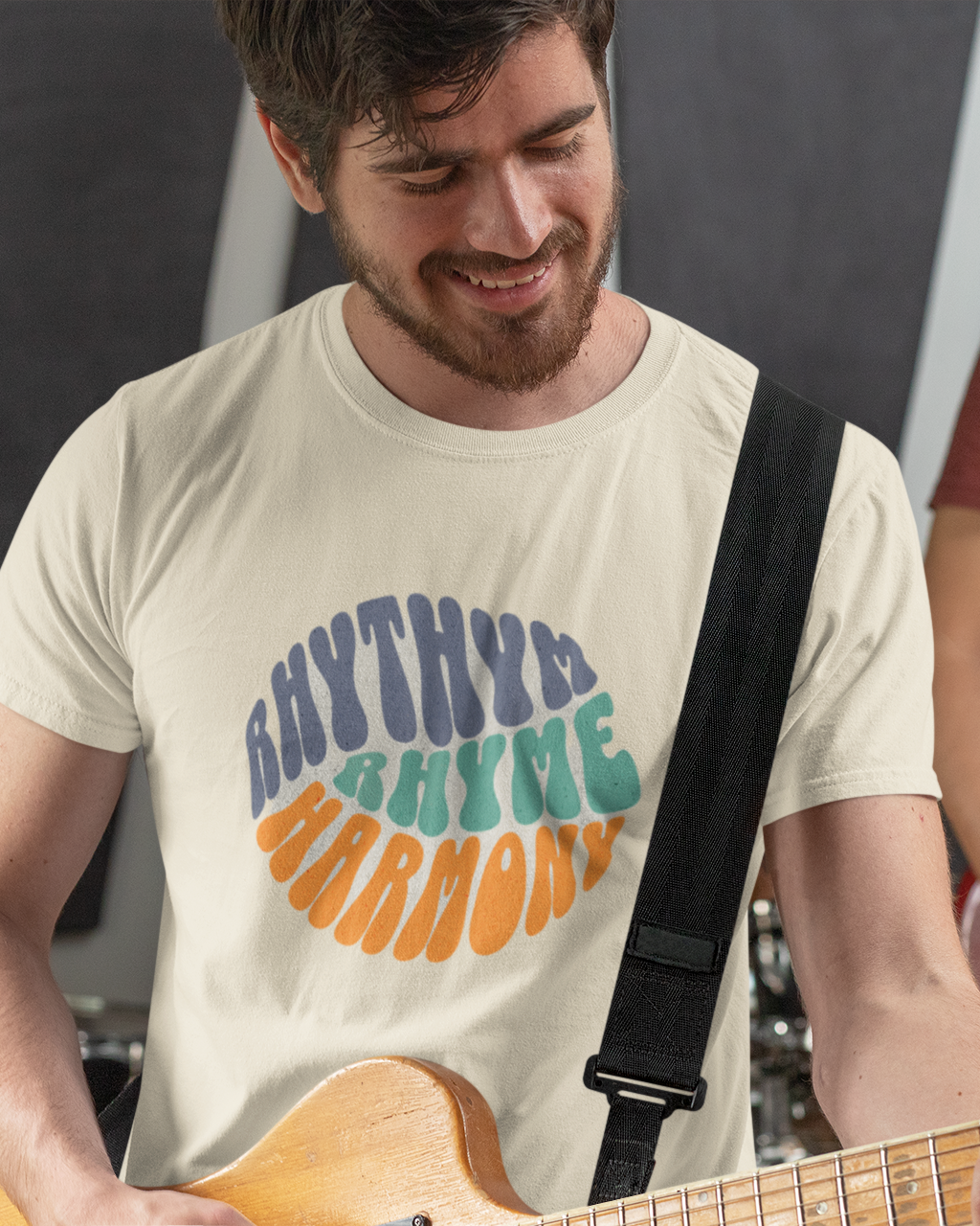 Two musicians playing guitars with one wearing a 'Rhythm and Harmony' t-shirt.